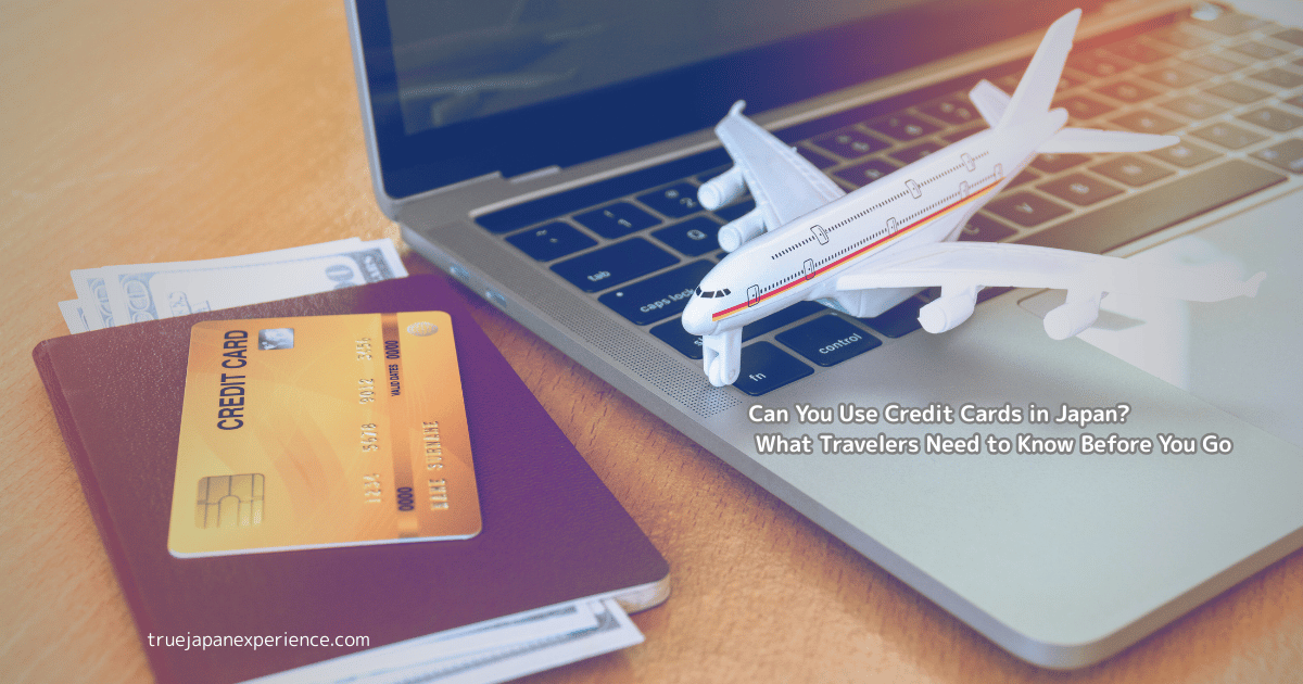 A credit card and passport next to a laptop and toy airplane, representing travel planning and card use in Japan.