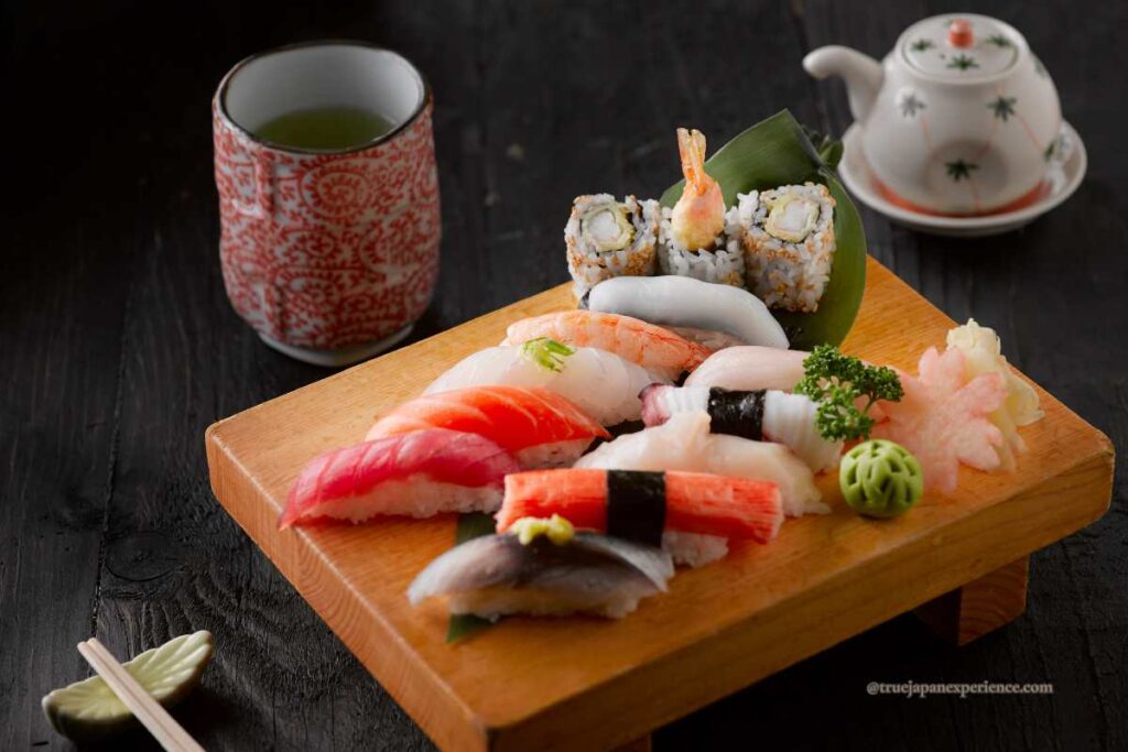 Edomae sushi platter with nigiri, maki rolls, and green tea