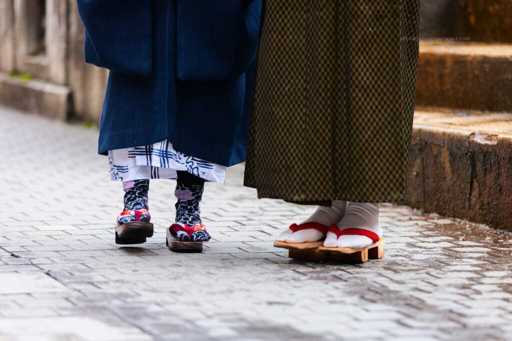 Close-up of traditional wooden geta sandals worn with kimono during a Japanese festival.