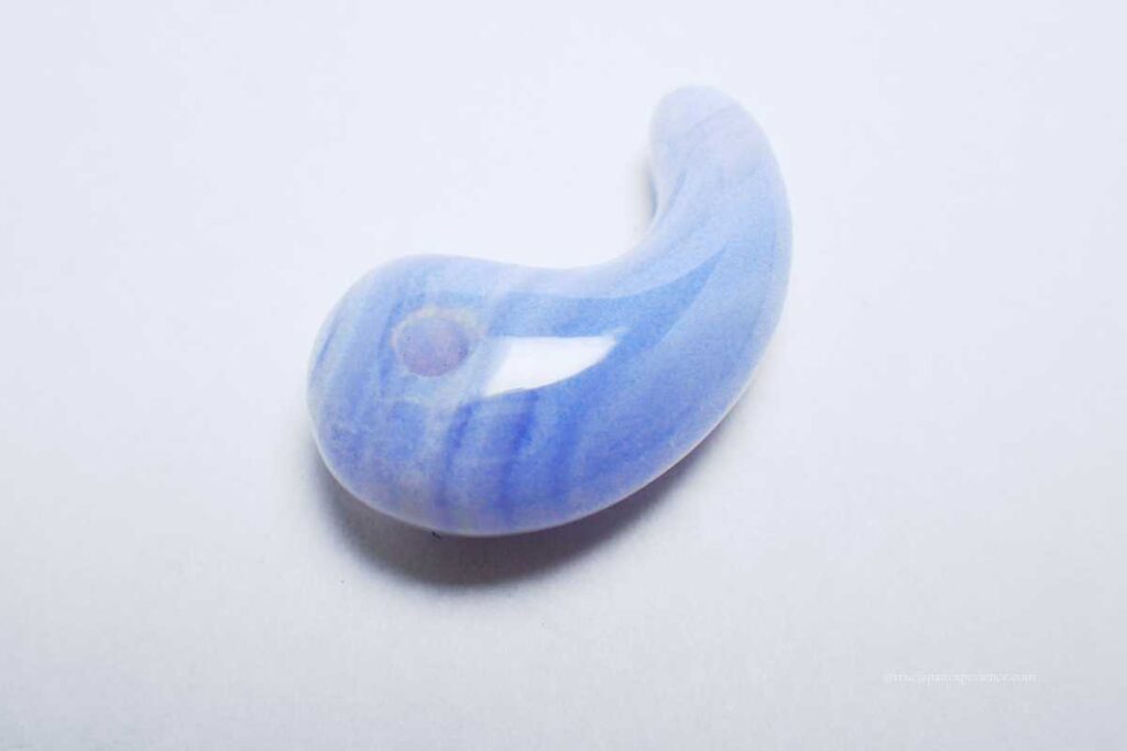 A blue magatama, a traditional Japanese curved bead used for protection.