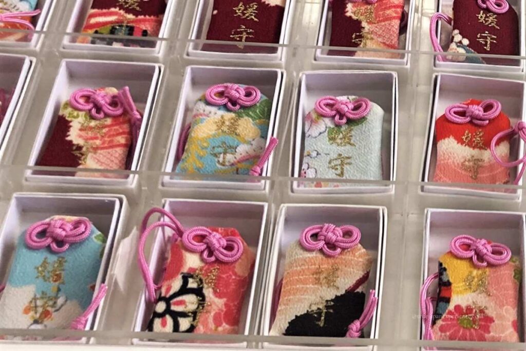 Hime-mamori charms from Shimogamo Shrine’s Aioi-sha, each with a unique kimono fabric design, offered for women’s protection and wishes.