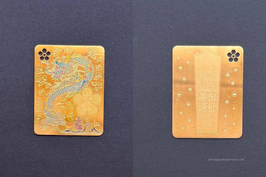 Gold omamori card from Dazaifu Tenmangu Shrine with a dragon design, believed to bring success and good fortune.