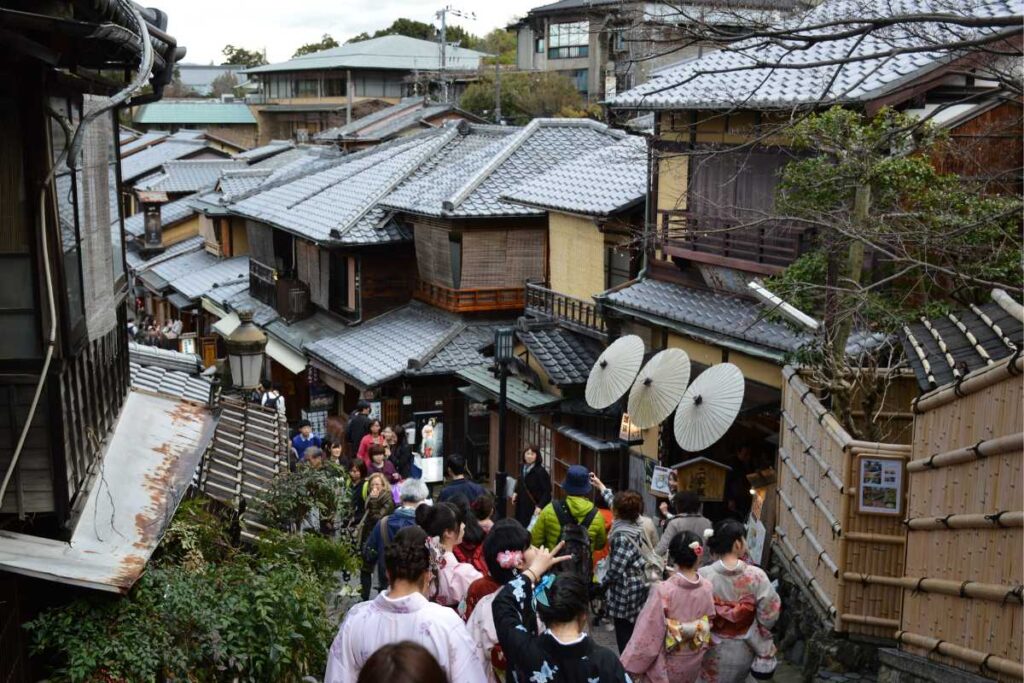 Tourists in kimono with umbrellas walking along Ninenzaka, Kyoto’s iconic sloped street