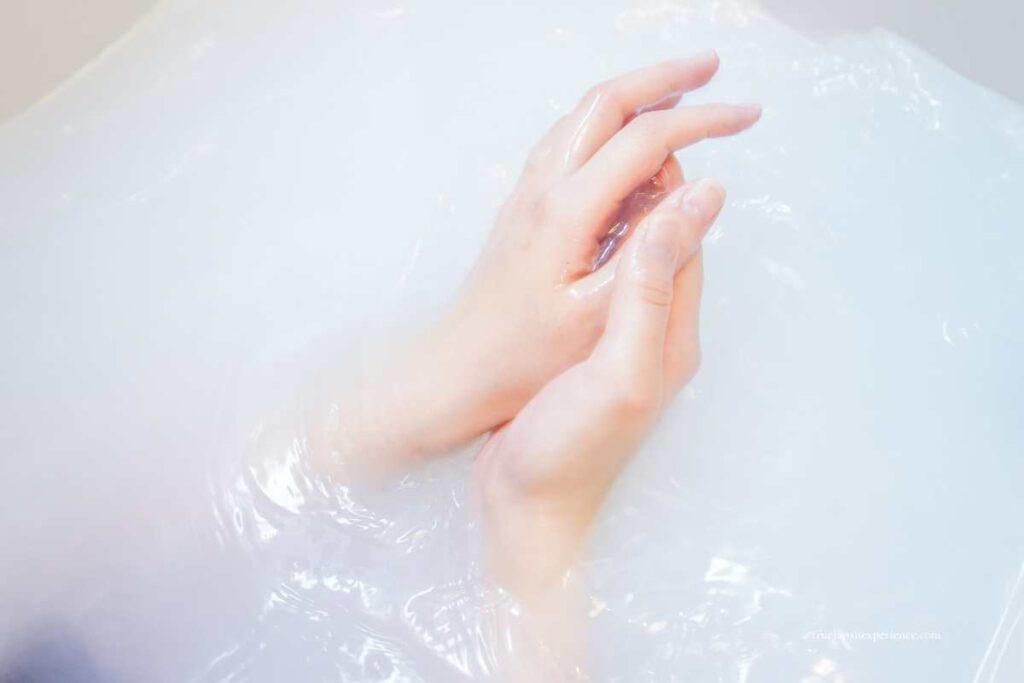 Hands in milky white hot spring water