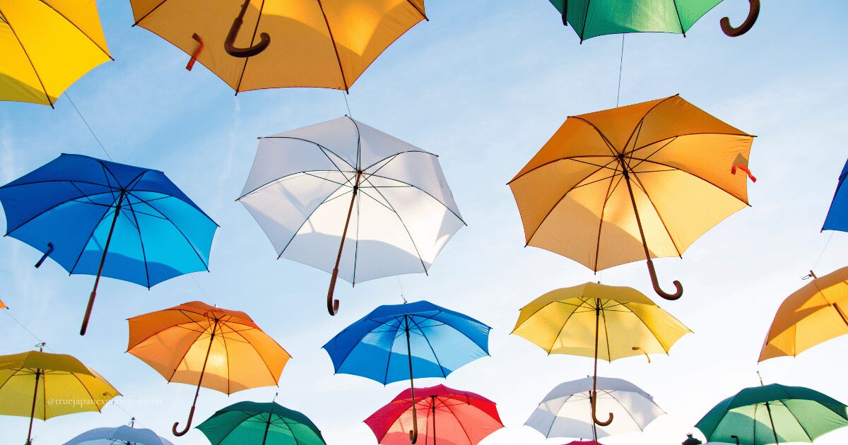 Colorful umbrellas suspended in the air against a bright blue sky, creating a cheerful and artistic canopy installation.