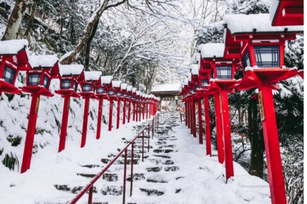 Snow-covered stone steps and red lanterns at Kifune Shrine in winter, creating a quiet and mystical atmosphere.