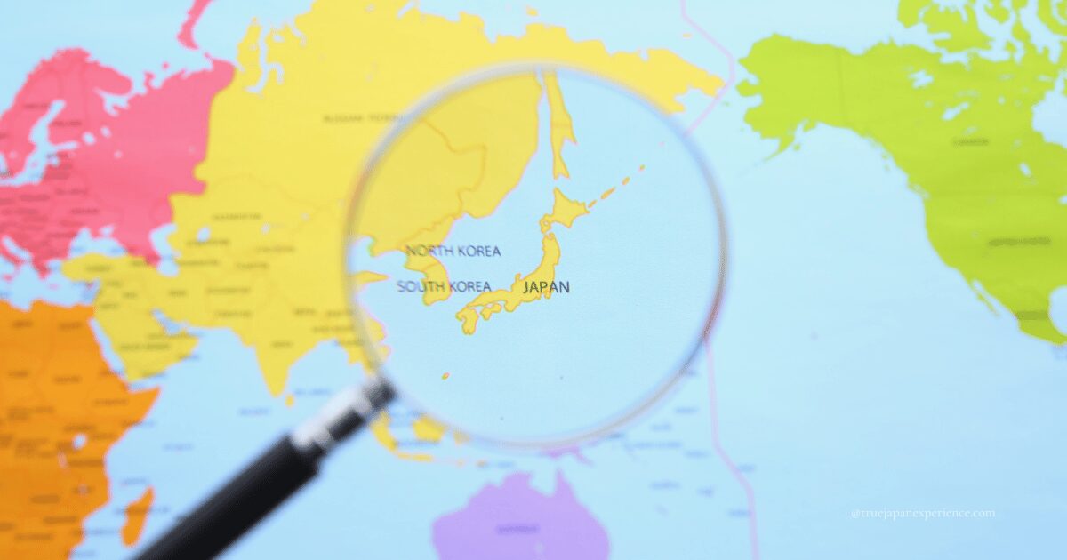 A magnifying glass highlighting Japan on a world map.