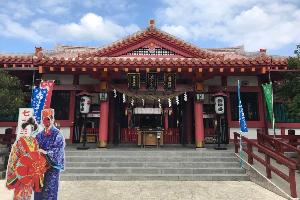 Front view of Naminoue Shrine in Okinawa with a traditional Ryukyuan costume photo panel for visitors.