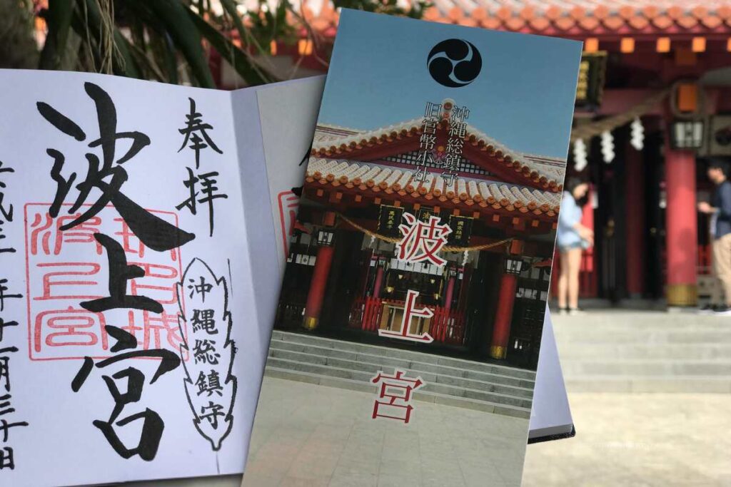 Goshuin stamp and brochure of Naminoue Shrine held in front of the shrine’s main hall in Okinawa.