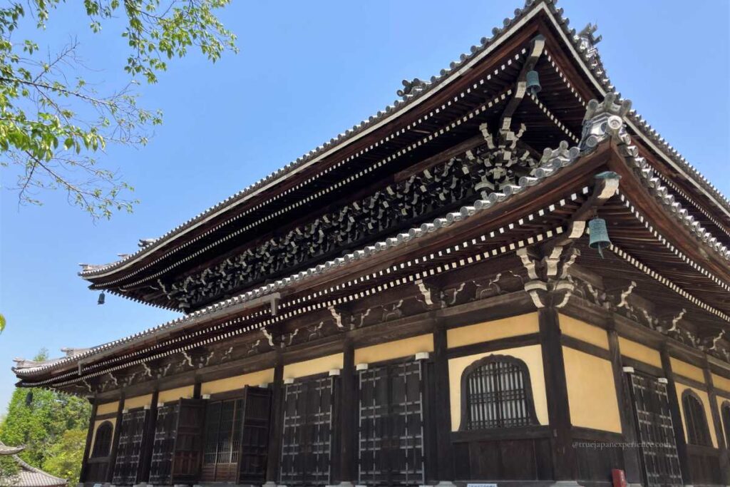 Close-up view of the main hall (Hatto) of Nanzen-ji Temple with detailed wooden architecture and blue sky.