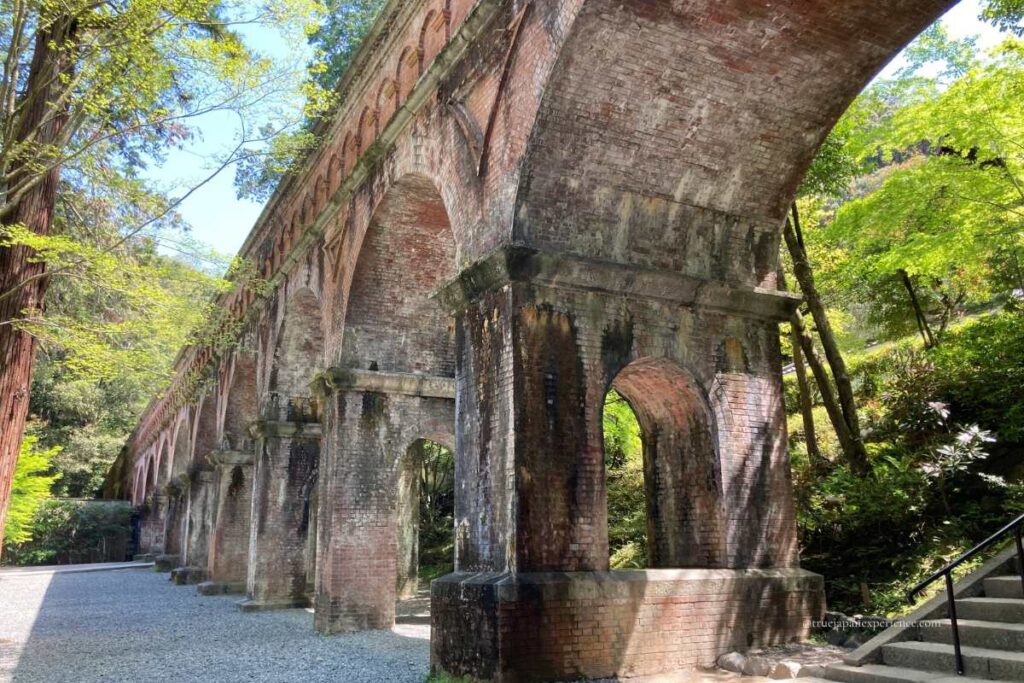 Brick arch of the Suirokaku Aqueduct in the Nanzen-ji Temple grounds, surrounded by fresh spring greenery.