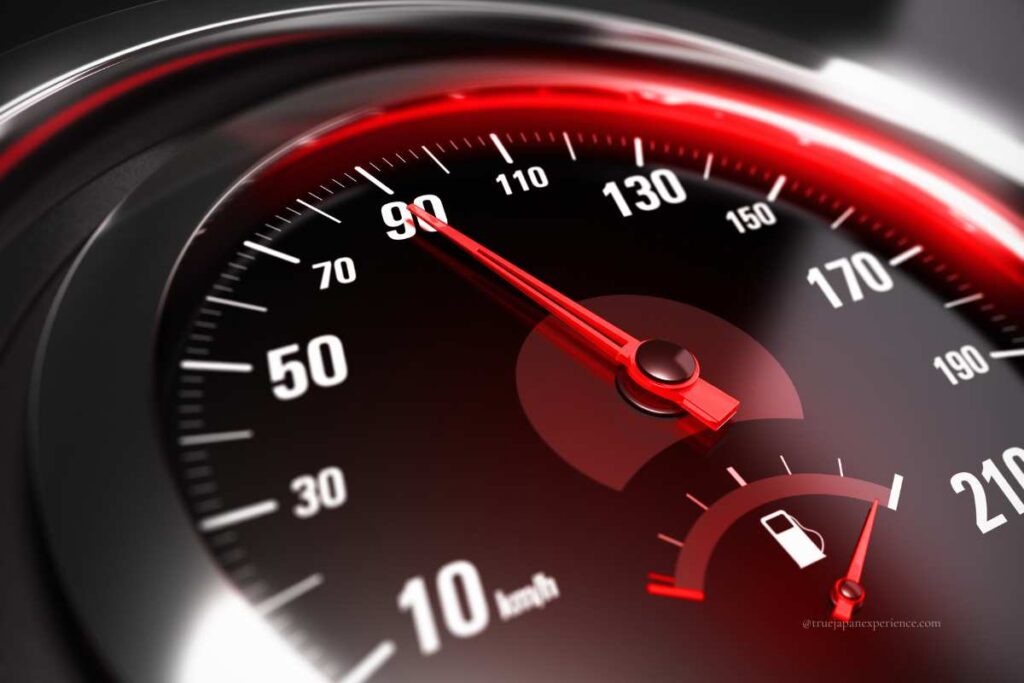 Close-up of a car speedometer showing 90 km/h, with a fuel gauge indicating a low fuel level.