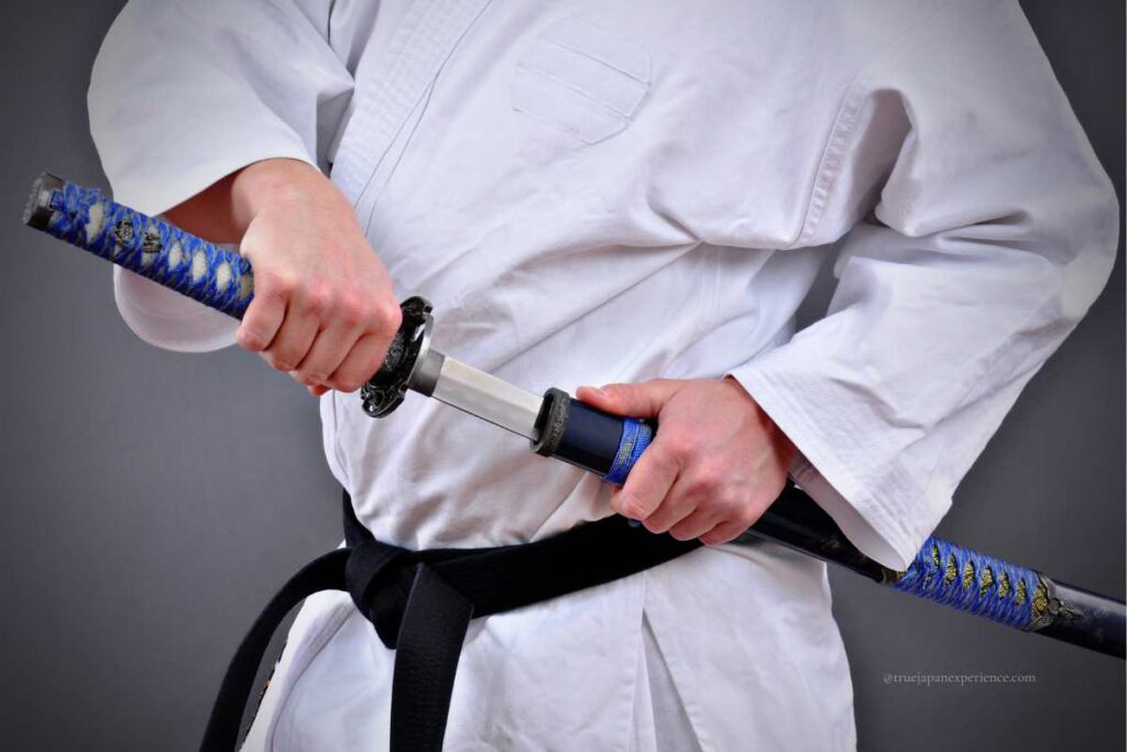 Person in martial arts uniform drawing a katana with both hands