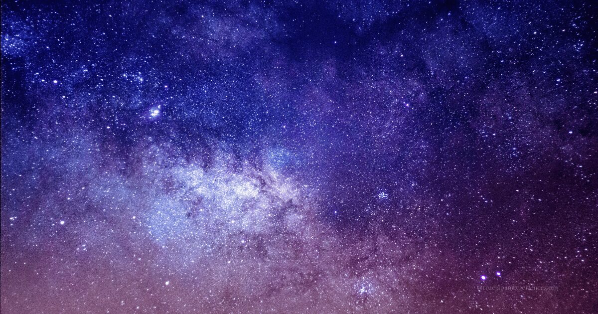 A breathtaking view of the Milky Way stretching across the night sky, filled with countless stars in shades of purple and blue.