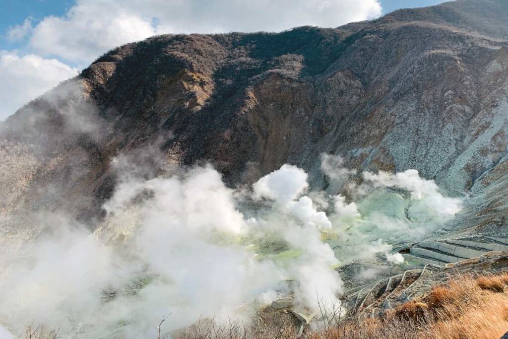 Steam rising from the volcanic valley of Owakudani in Hakone, with rugged mountain slopes in the background.