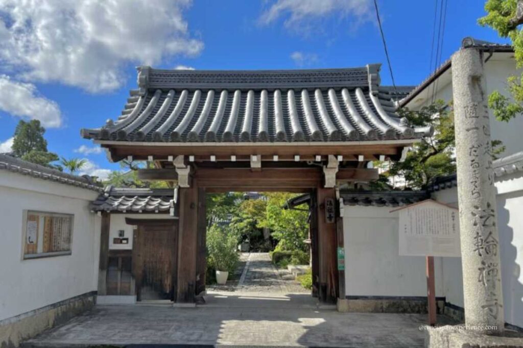 Traditional wooden gate of Darumadera Temple Kyoto with stone pillar and pathway leading inside