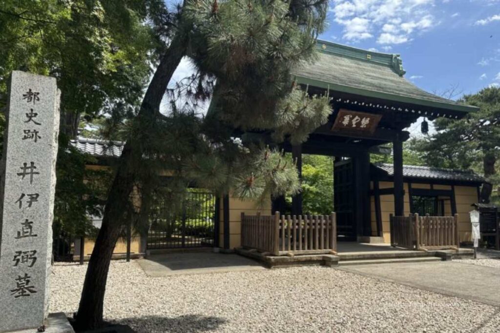 Entrance gate to the Ii Naosuke grave site at Gotokuji Temple in Tokyo, Japan, with a stone monument in the foreground