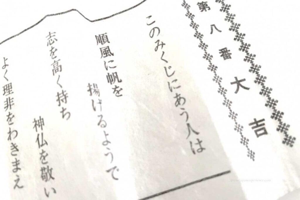 Close-up of a Japanese omikuji fortune slip showing "Daikichi" (Great Blessing) written in bold kanji characters.