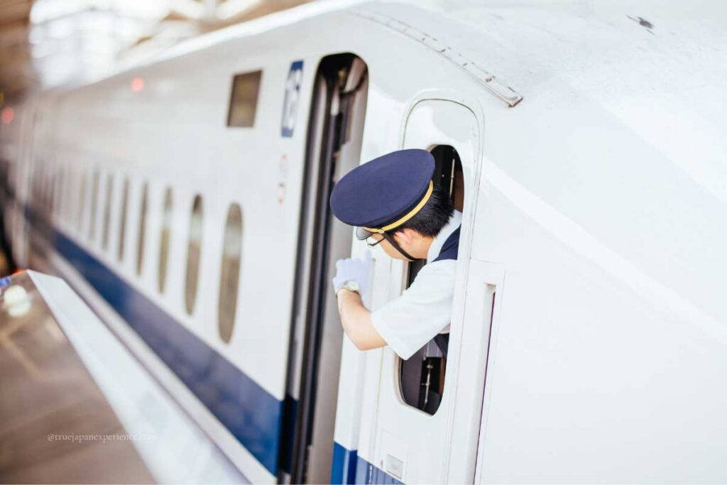 Japanese Shinkansen staff checking the platform before departure