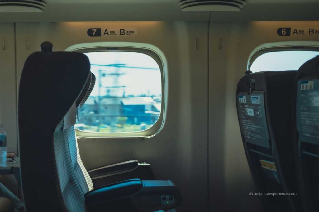Empty seats on a Japanese Shinkansen bullet train, looking out the window