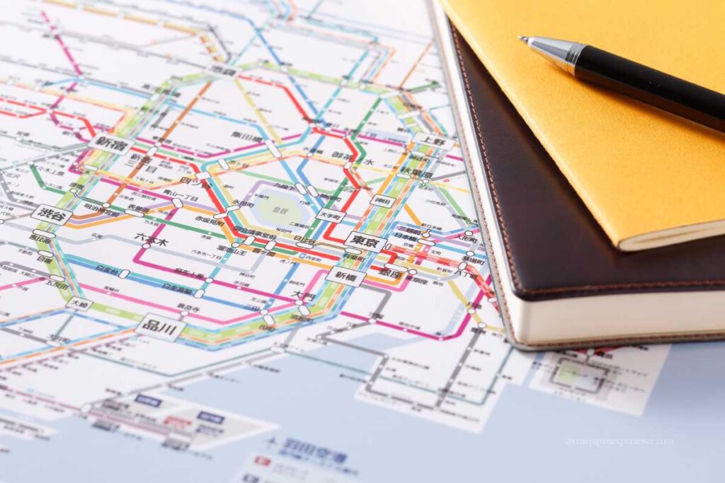 Close-up of a Tokyo railway map with notebooks and a pen on the desk
