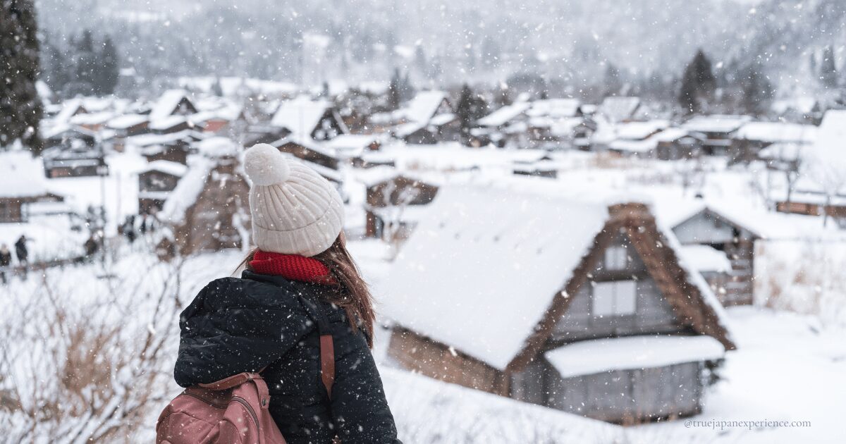 Tourist wearing warm clothes enjoying Japan winter weather in Shirakawa-go, Gifu