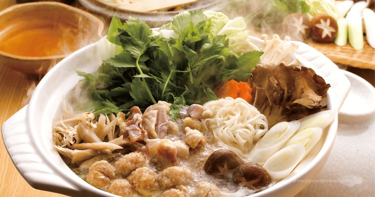 A hot Japanese winter hotpot filled with vegetables, mushrooms, meat, and noodles steaming in a clay pot