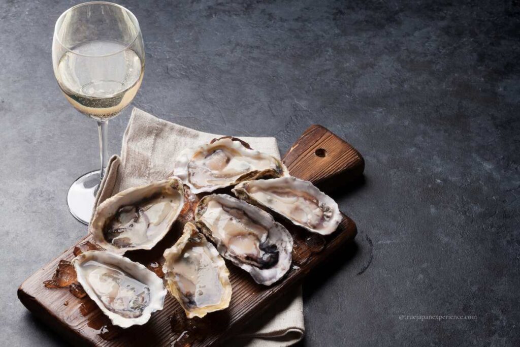 Fresh Japanese oysters on ice served with a glass of white wine on the side