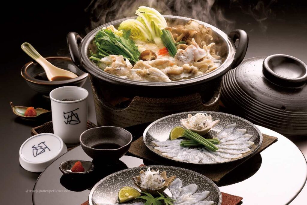 Traditional Japanese fugu (pufferfish) cuisine with sashimi and hot pot, served with condiments and sake