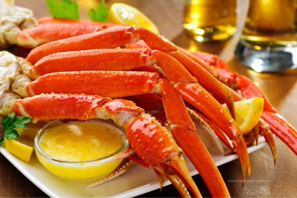 Boiled Japanese crab legs served with melted butter and lemon on a plate